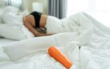 Close up of cucumber foods for erotic sex education on bed in bedroom.