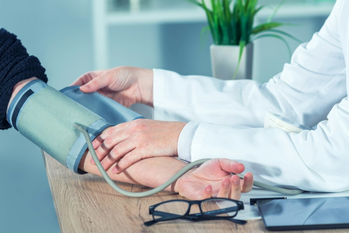 Doctor cardiologist measuring blood pressure of female patient