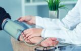 Doctor cardiologist measuring blood pressure of female patient