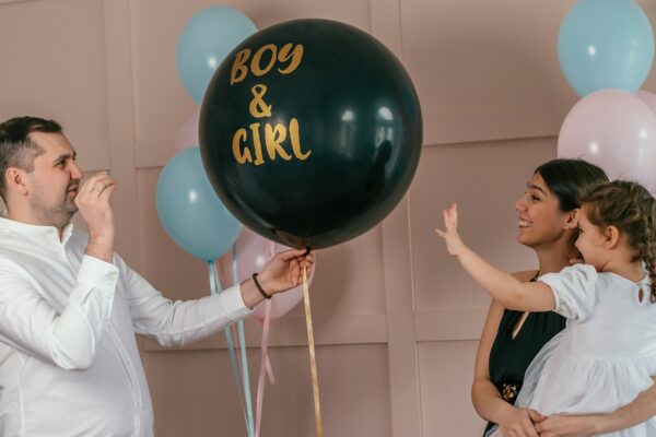 Expectant parents are having a gender reveal party, pink confetti.