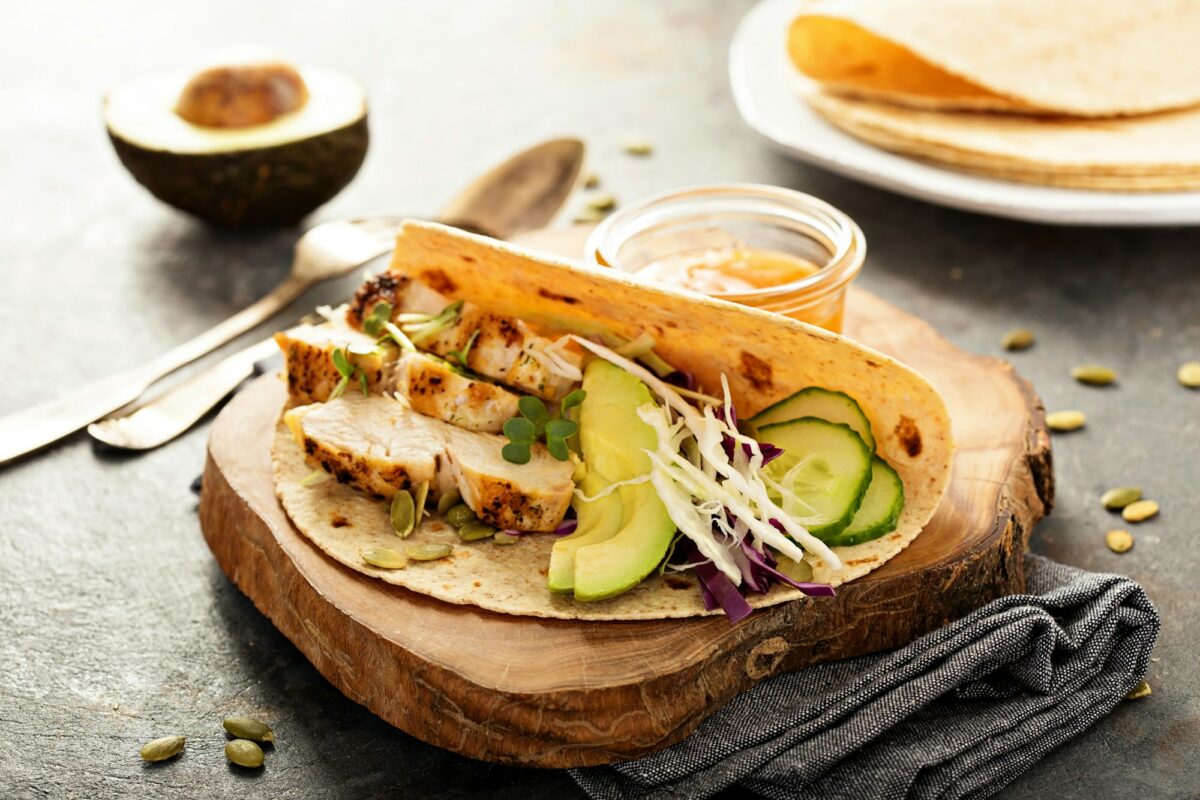 Making tacos with grilled chicken and avocado