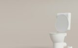 Toilet, WC on beige background with copy space. Hygiene, defecation, problems with digestion