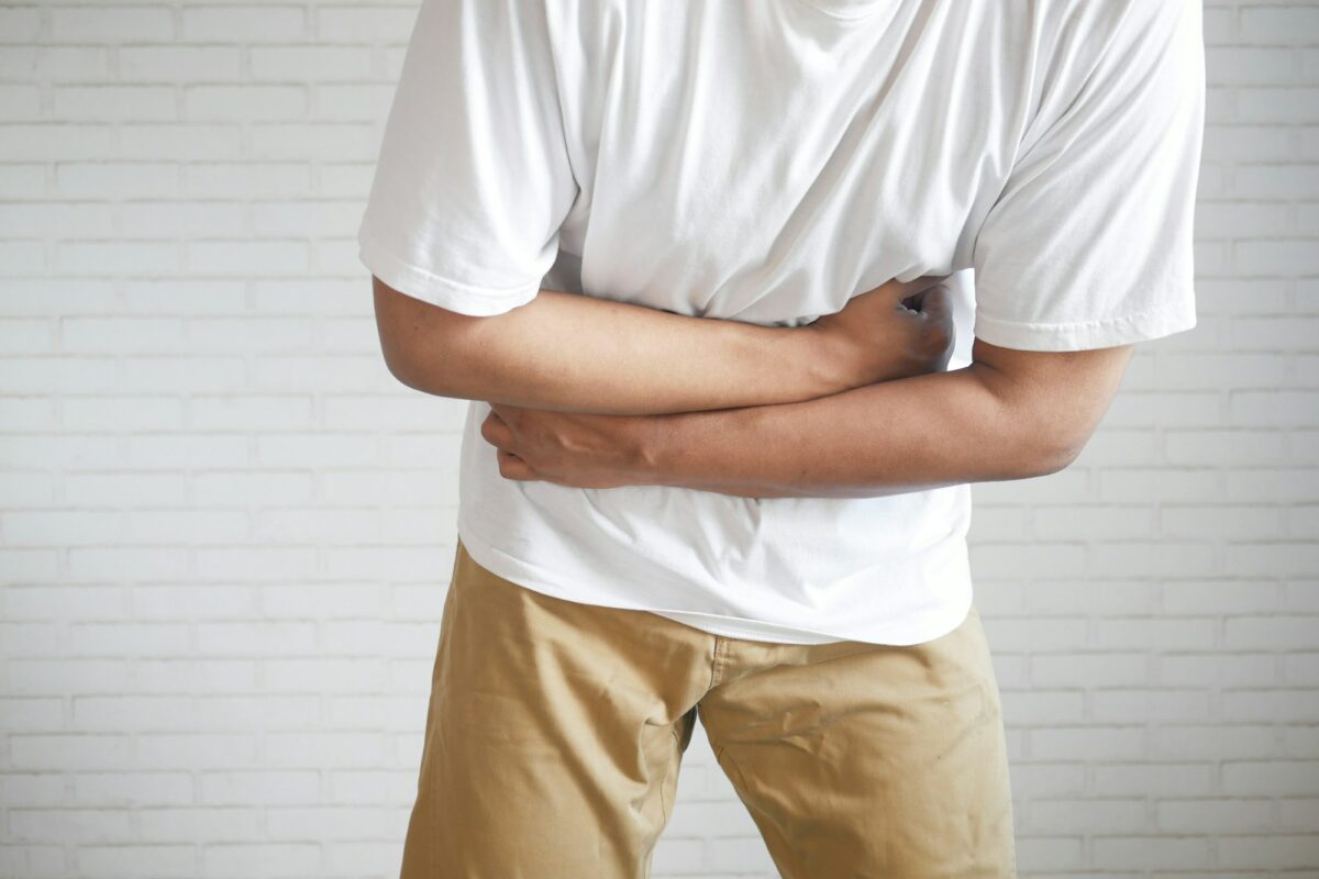 young man suffering stomach pain close up.