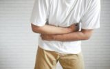 young man suffering stomach pain close up.