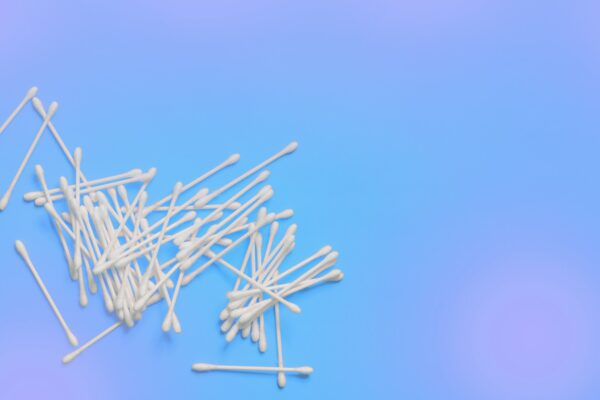 Ear sticks on blue purple background. Makeup removal and skin care concept. Space for text
