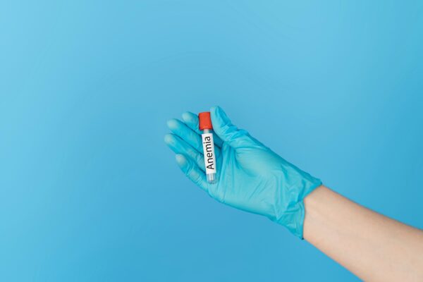 Hand holding test tube with the inscription anemia