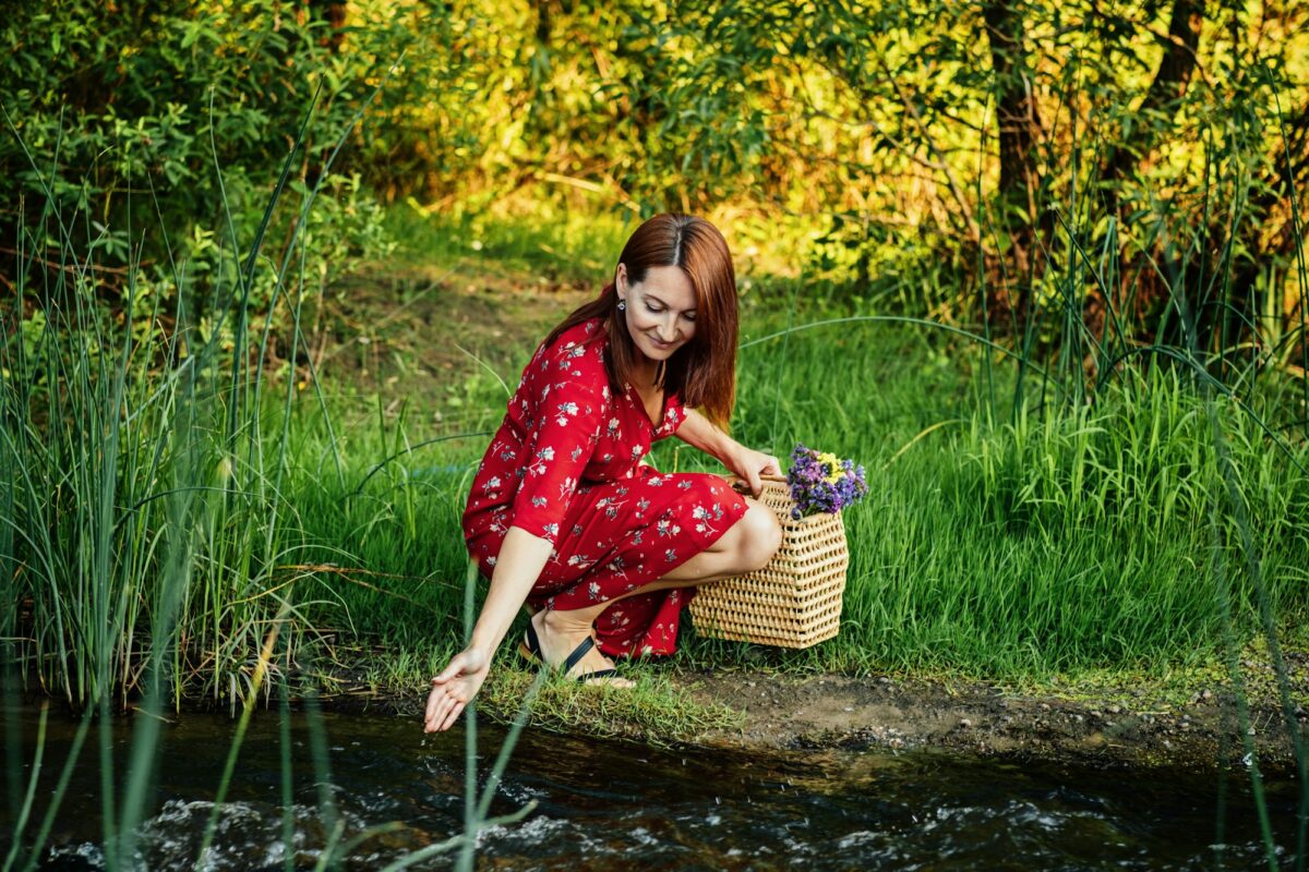 Nature Impact Wellbeing. Woman in red dress enjoying nature.