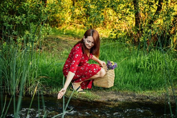 Nature Impact Wellbeing. Woman in red dress enjoying nature.