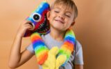 Positive little boy 6 years old with a bright colored toy. Concept: kindergarten, imaginary friend