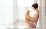 Pregnant woman in white underwear with cute ginger cat. Risk of infection toxoplasmosis.