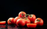 Ripe tomatoes on a branch and tomato halves.