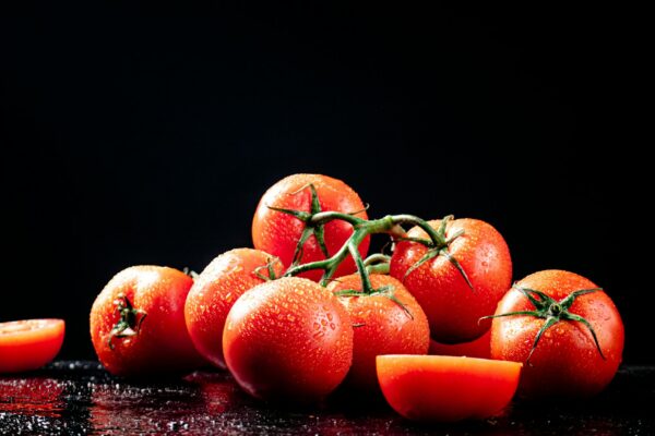Ripe tomatoes on a branch and tomato halves.