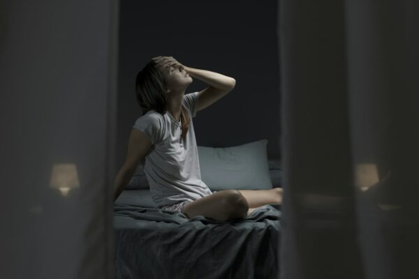 Tired sleepless woman suffering from the heat in bed