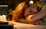 Tired woman sleeping at her workplace