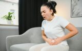 Young woman suffering from menstrual cramps at home. Gynecology