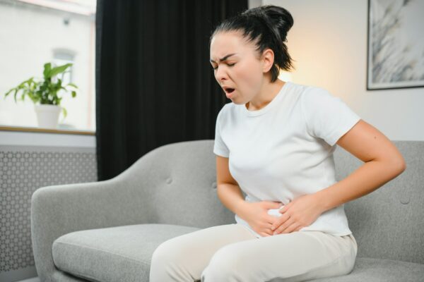 Young woman suffering from menstrual cramps at home. Gynecology