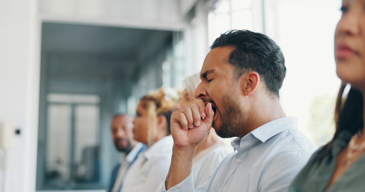 Tired, yawn and sleepless with a business man sitting in a meeting or presentation with his team fo