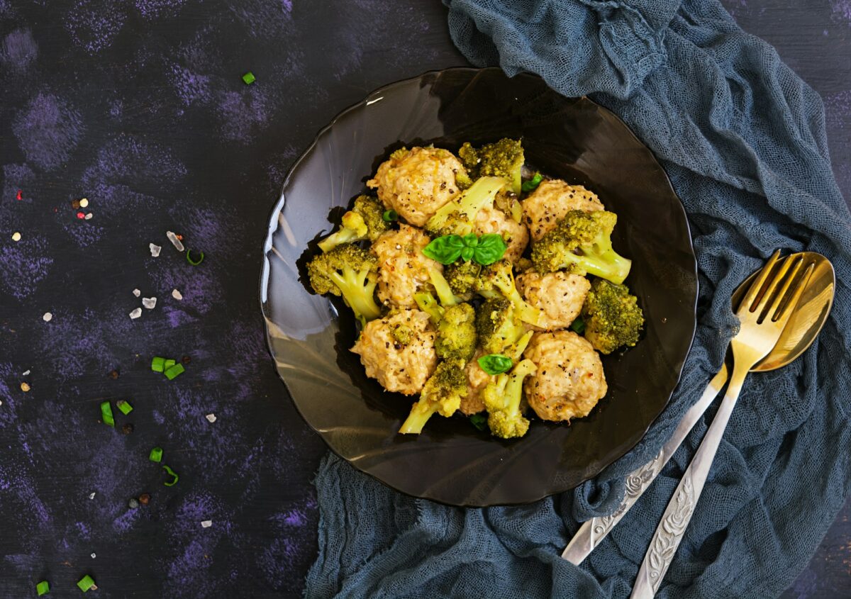 Chicken meatballs with broccoli on dark background