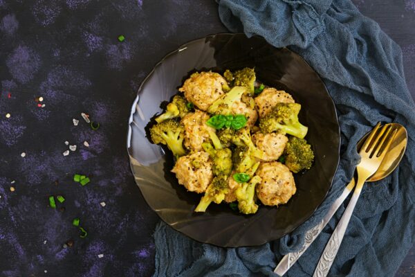 Chicken meatballs with broccoli on dark background