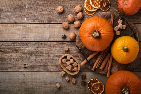 Pumpkin. Autumn food background with cinnamon, nuts and seasonal spices on rustic background. Cookin