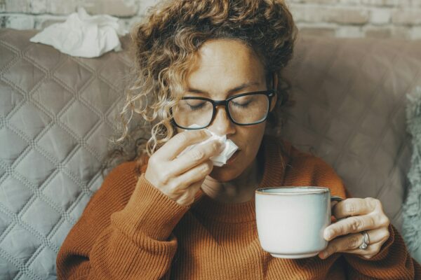 Sick woman at home blowing nose and take care of influenza virus disease. One female people