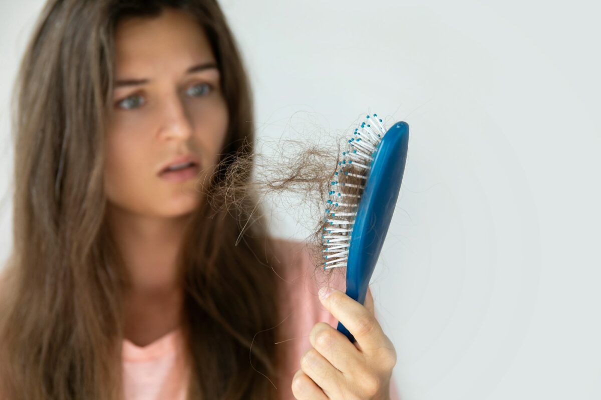 Young woman is upset because of hair loss