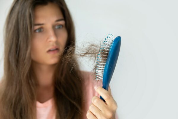 Young woman is upset because of hair loss