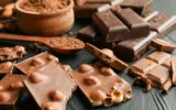 Chocolate, melted chocolate and almond on black background
