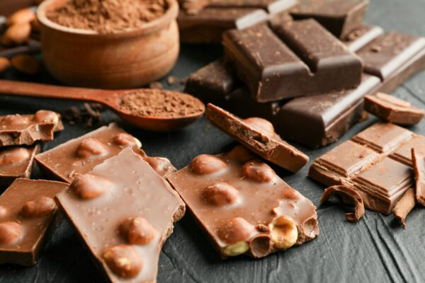 Chocolate, melted chocolate and almond on black background