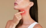 Closeup of unrecognizable sick lady suffering from sore throat, touching neck with hand, inflamed