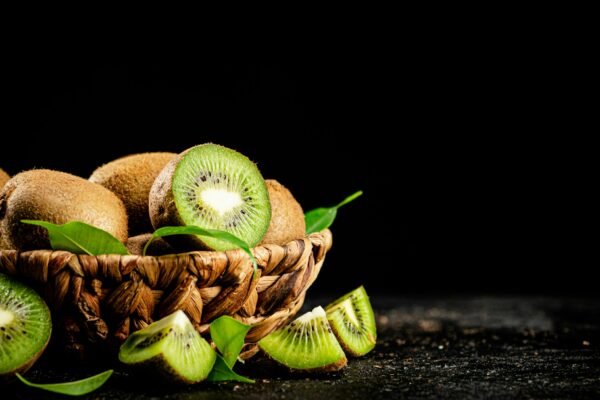 Fresh kiwi with leaves in a basket.