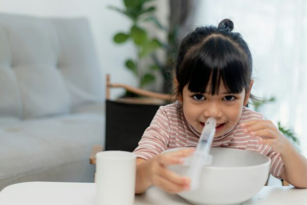 Little asian girl saline nasal wash nose at home.
