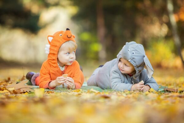 Little children in animal costumes playing in autumn forest