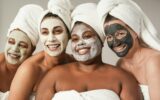 Multiracial women enjoy spa day together with beauty face mask while wearing towels