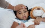 Sick child, covid and medical emergency in bed of home, healthcare problem in bedroom of house and