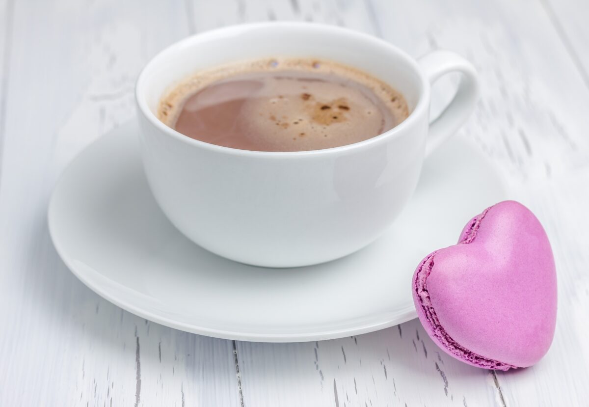 A cup of hot chocolate with a heart-shaped macaron