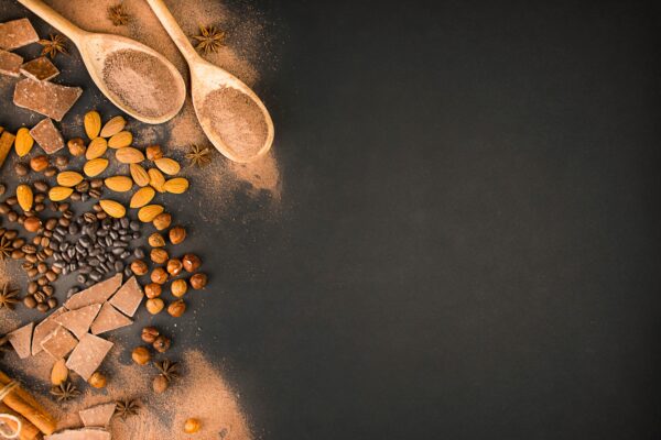 Chocolate background from different types of nuts, chocolate slices, coffee beans and cocoa.
