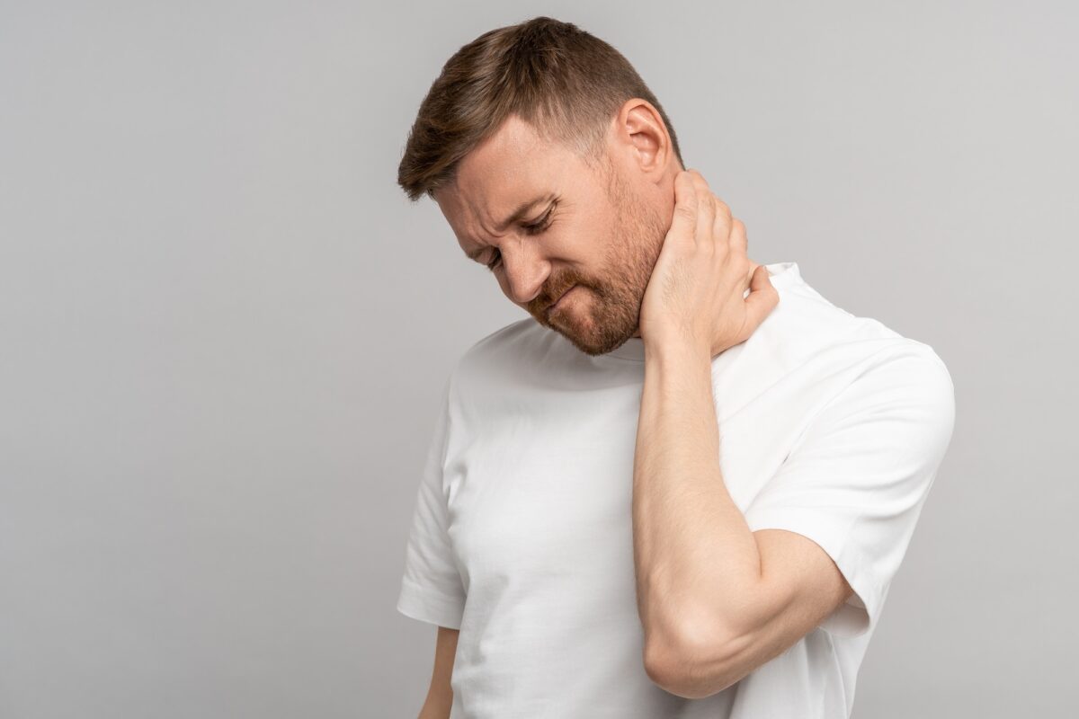 Unhealthy man suffering painful neck ache after sports exercise. Back pain and hernia, sedentary.