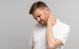 Unhealthy man suffering painful neck ache after sports exercise. Back pain and hernia, sedentary.