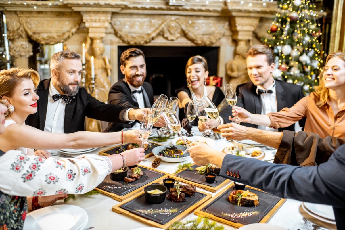Elegantly dressed people celebrating New Year holiday indoors