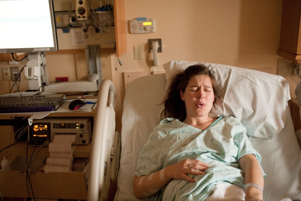 Pregnant woman in labor on hospital bed