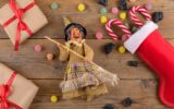 The witch Befana and red stocking with sweet coal and candy on rustic wooden background
