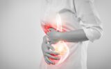Woman hands touching belly and stomach painful suffering from chronic gastritis on white background.